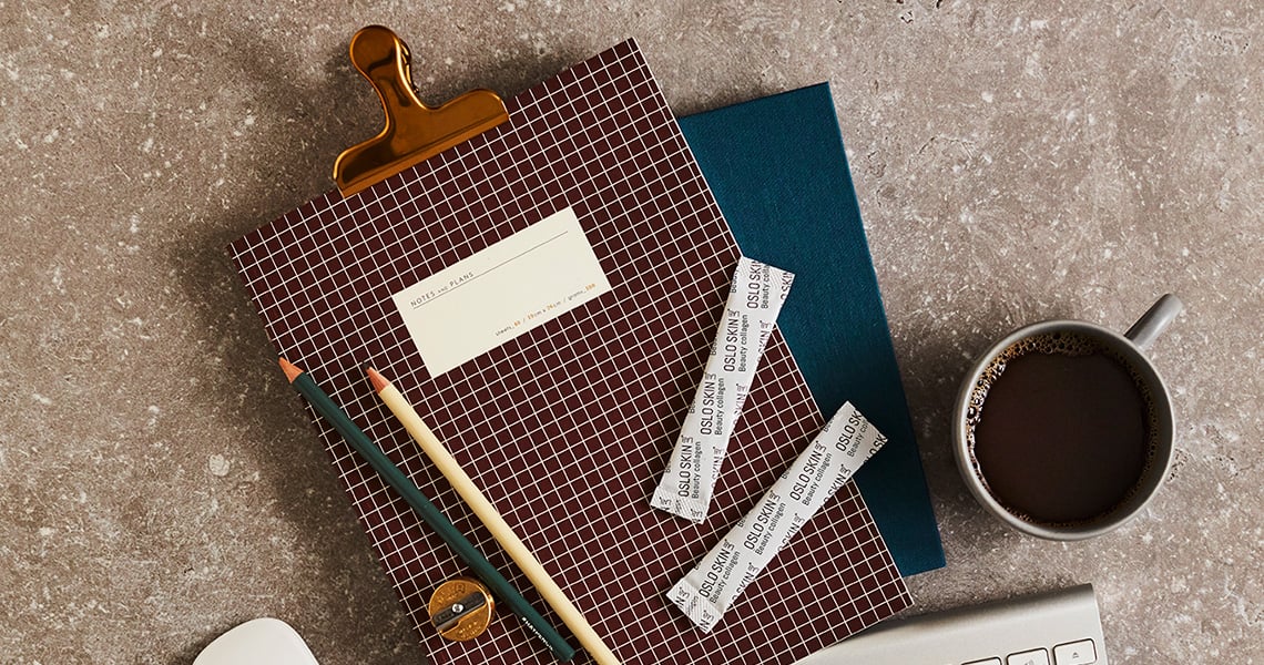Un agenda avec deux sticks de The Solution posés dessus et une tasse de café à côté