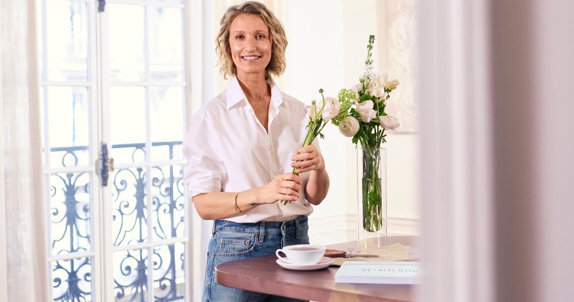 Alexandra Lamy avec des fleurs et une boite The Solution Beauty Collagen